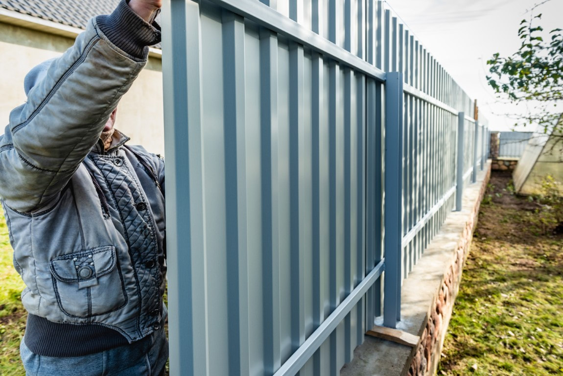 A picture of a person working with an aluminum fence