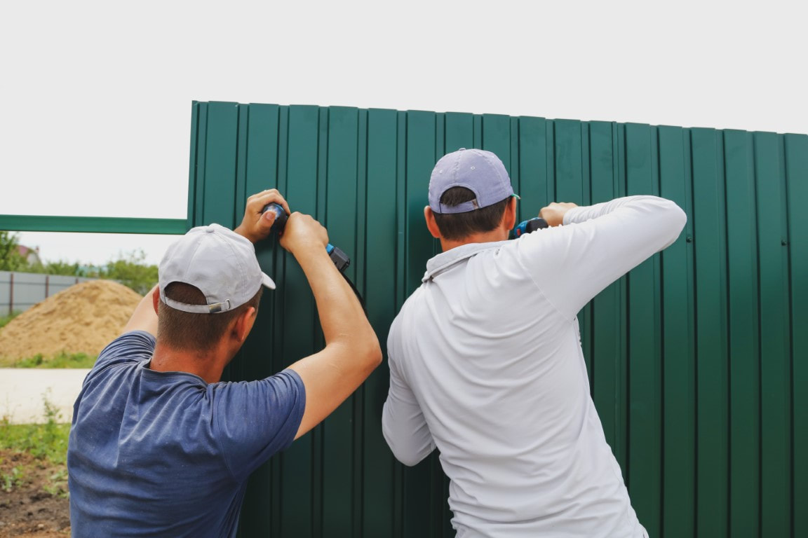 A picture of two men doing fence installation