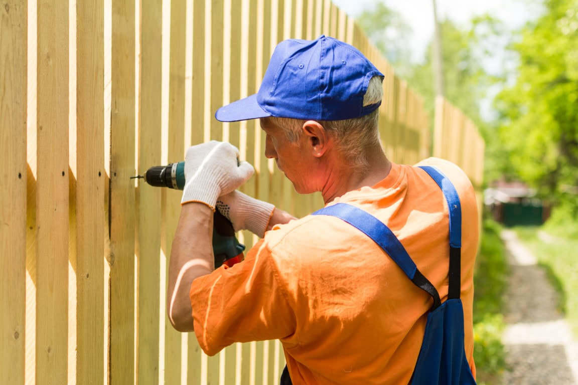 A picture of a man doing fence installation